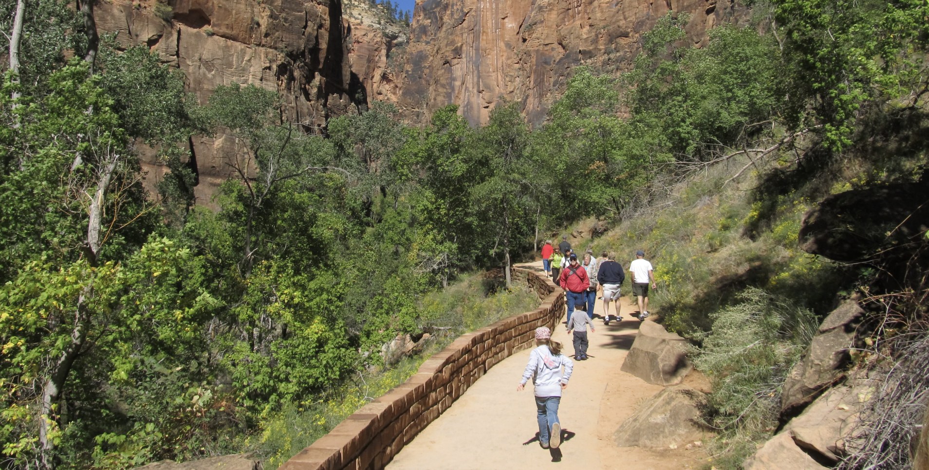 Families on the Paved Riverside Walk Visitors including young children walking the paved Riverside Walk below canyon walls in Zion