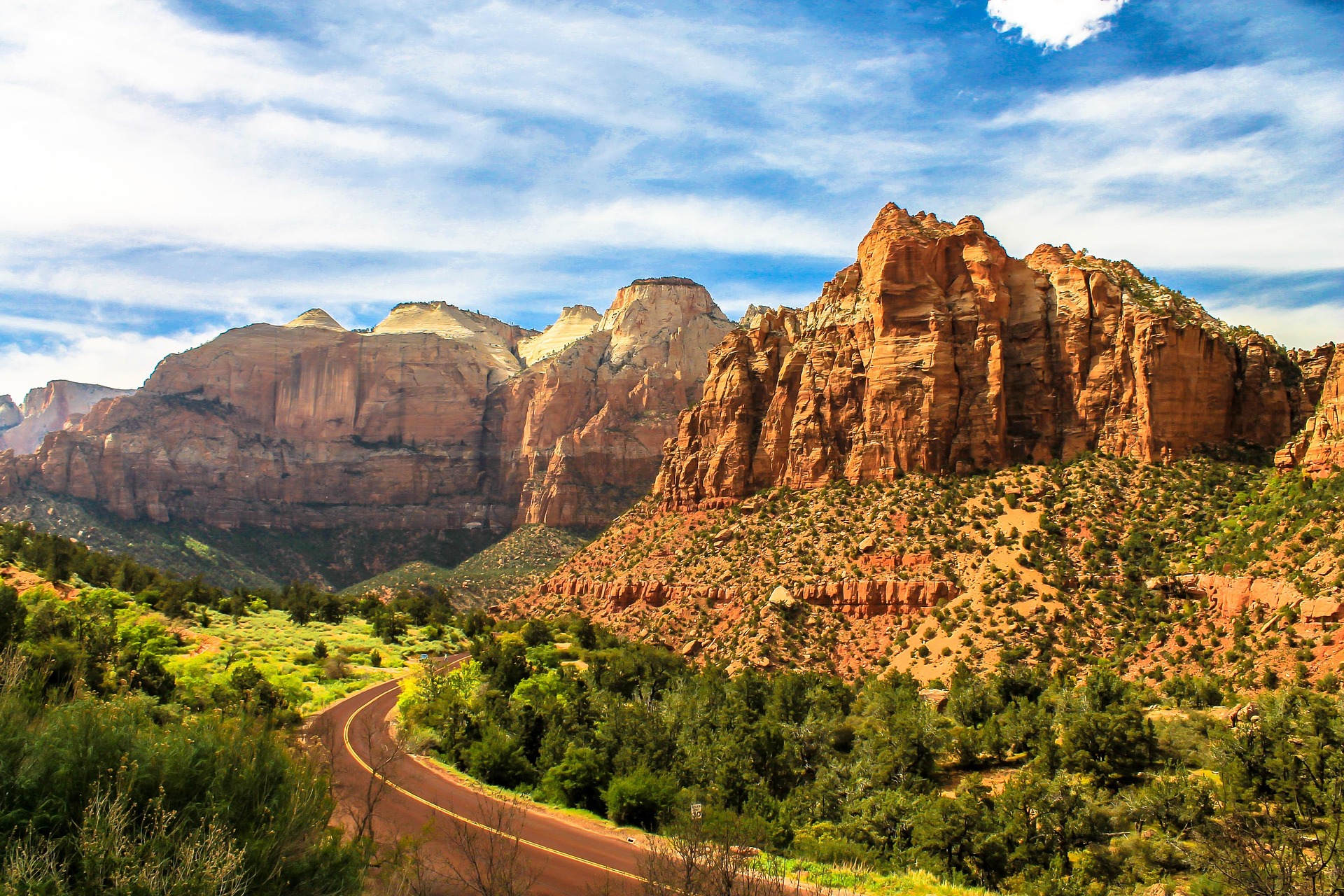 Zion Canyon Scenic Drive A paved road winds through Zion Canyon beneath towering red and tan sandstone cliffs