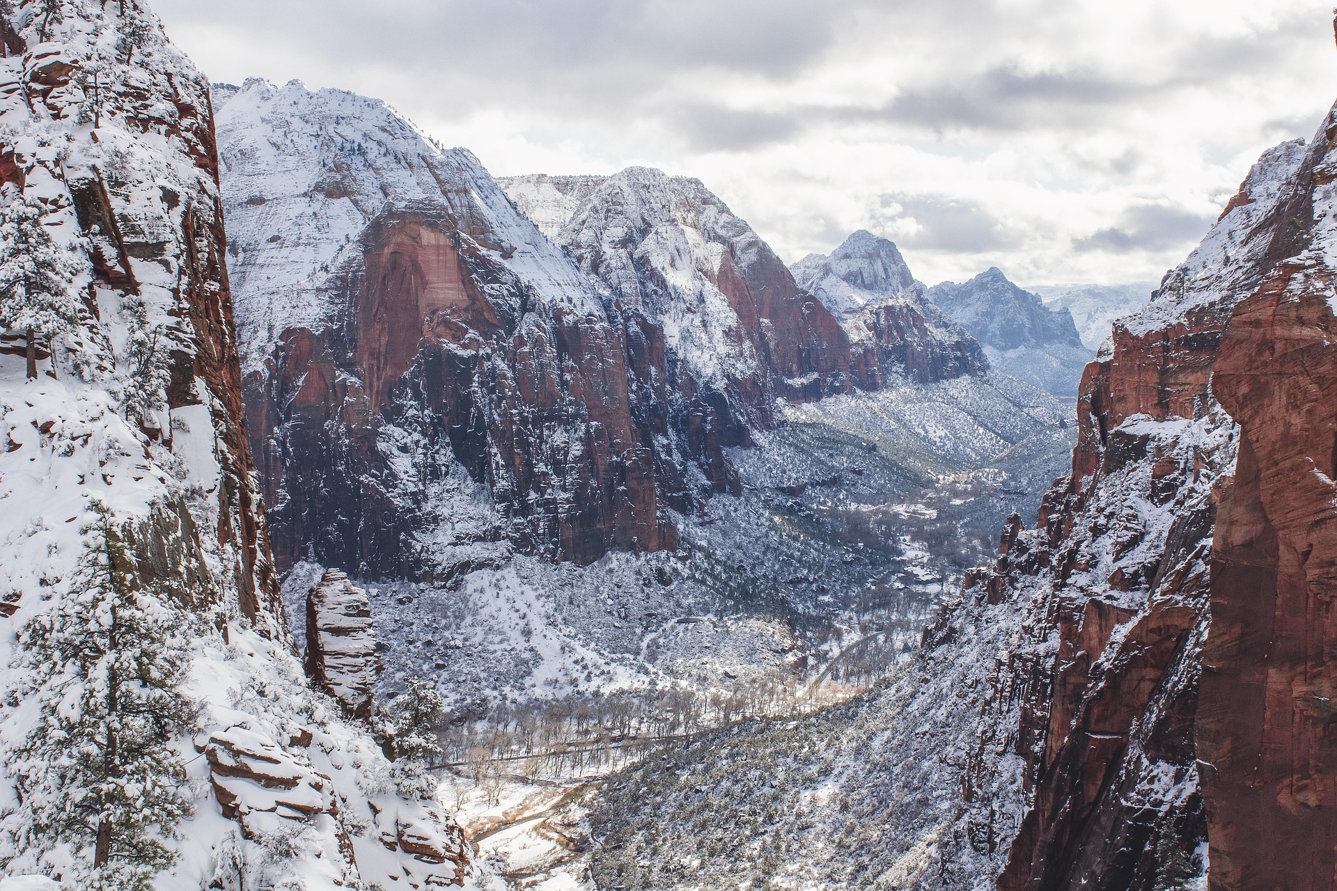 Snow covered cliffs and the floor of Zion Canyon seen from a high viewpoint on a cloudy winter day