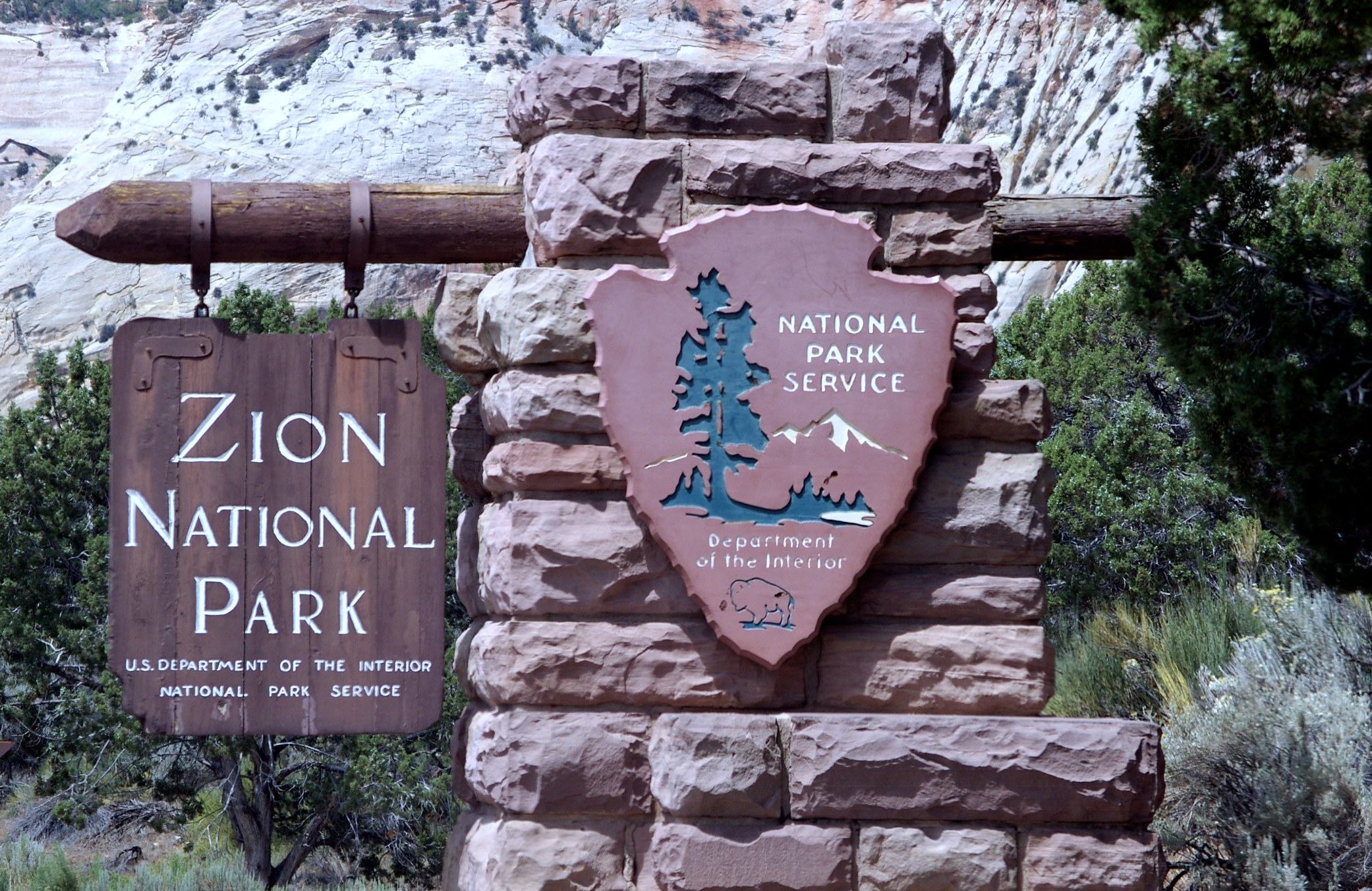 National Park Service Arrowhead at the Zion Entrance Close view of the Zion National Park sign and the stone mounted National Park Service arrowhead
